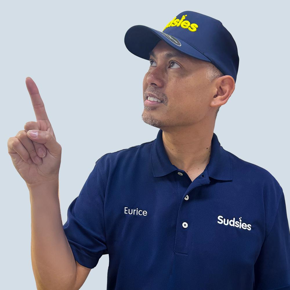 Sudsies team member Eurice pointing upward in branded uniform