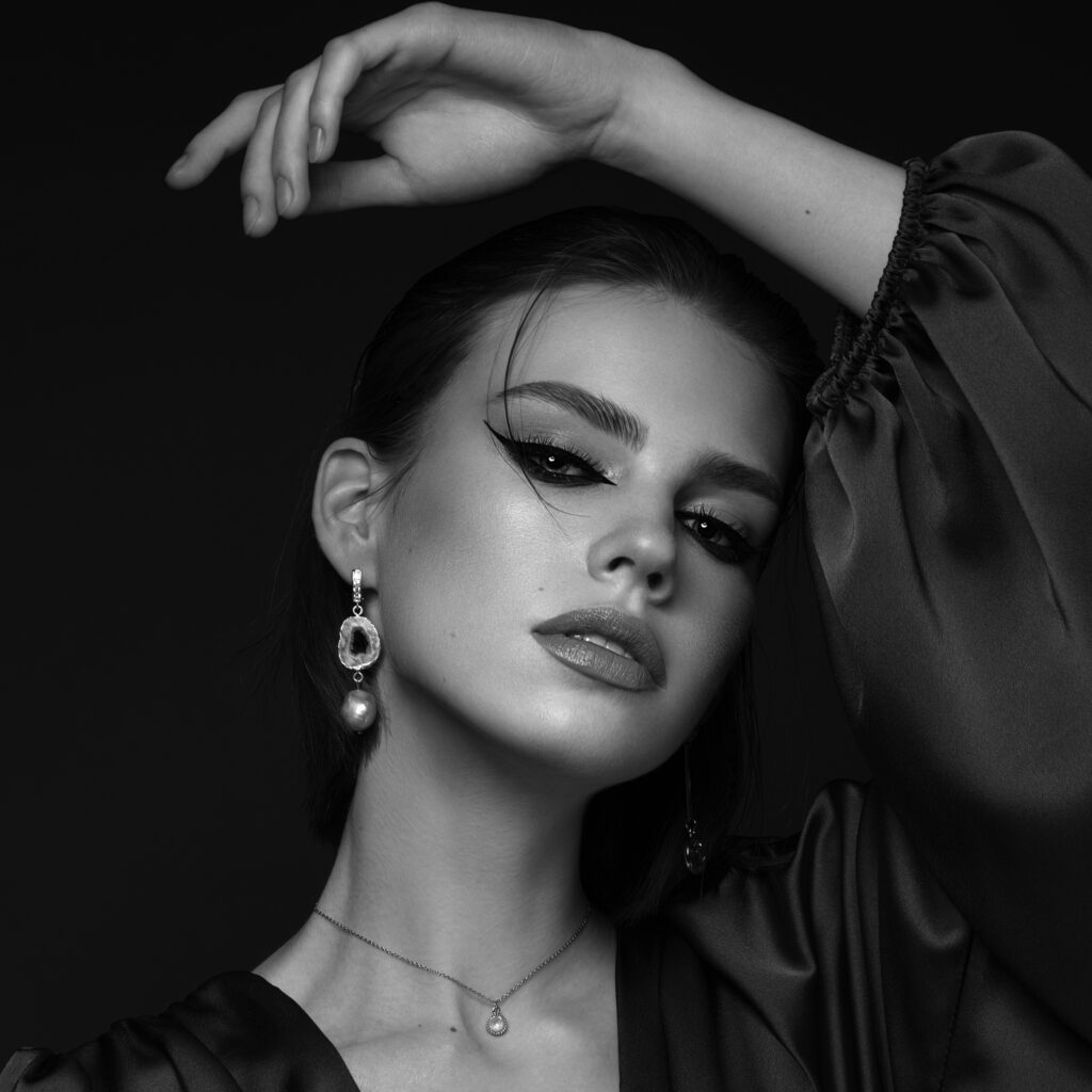 Black-and-white editorial portrait of a woman wearing an elegant draped garment