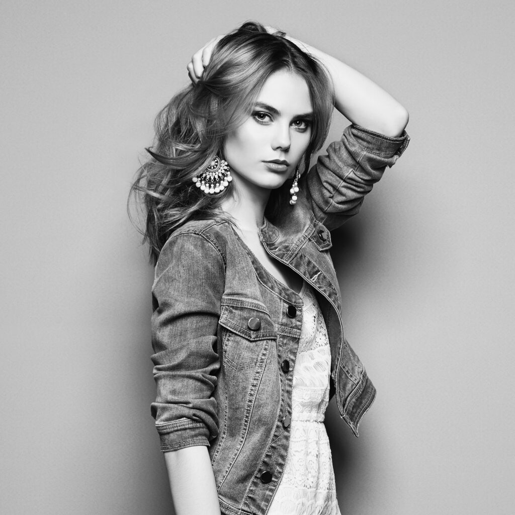 Black-and-white fashion portrait of a woman wearing a summer dress and lightweight jacket