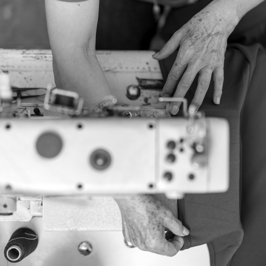 Close-up of skilled hands working on a garment using professional sewing equipment
